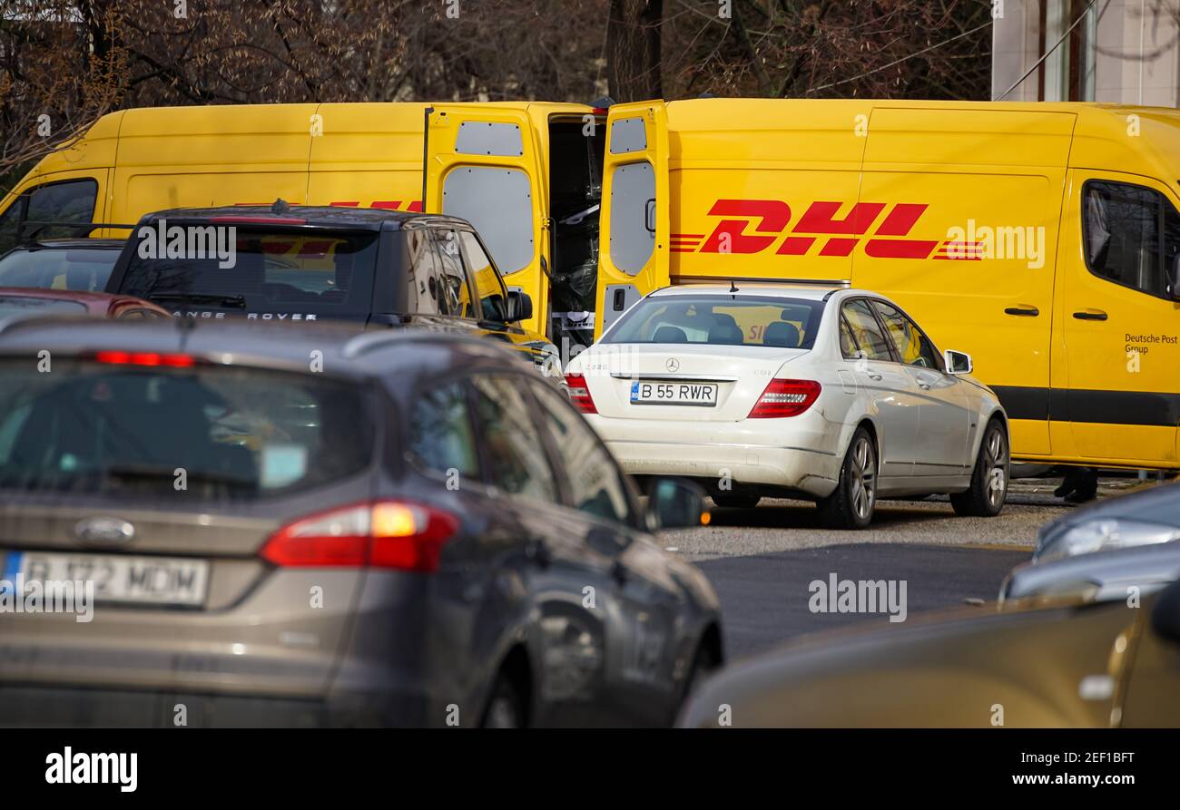 Bucarest, Romania - 25 gennaio 2021 due furgoni di consegna DHL gialli sono visti trasferire i pacchetti su una strada a Bucarest. Questa immagine è per editoria Foto Stock