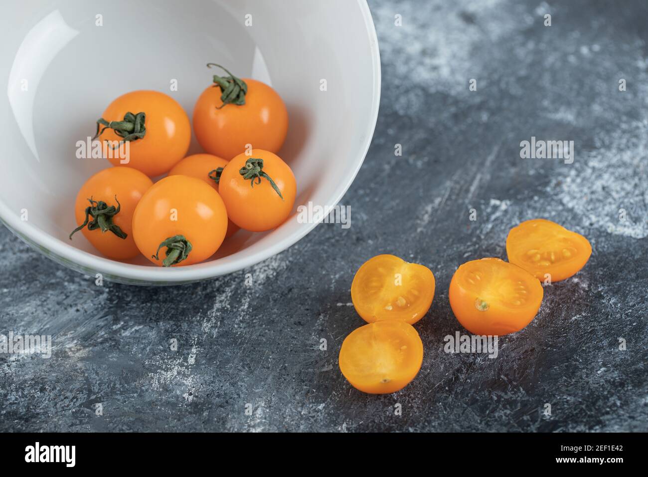 Pomodori ciliegini rossi interi o tagliati a metà Foto Stock