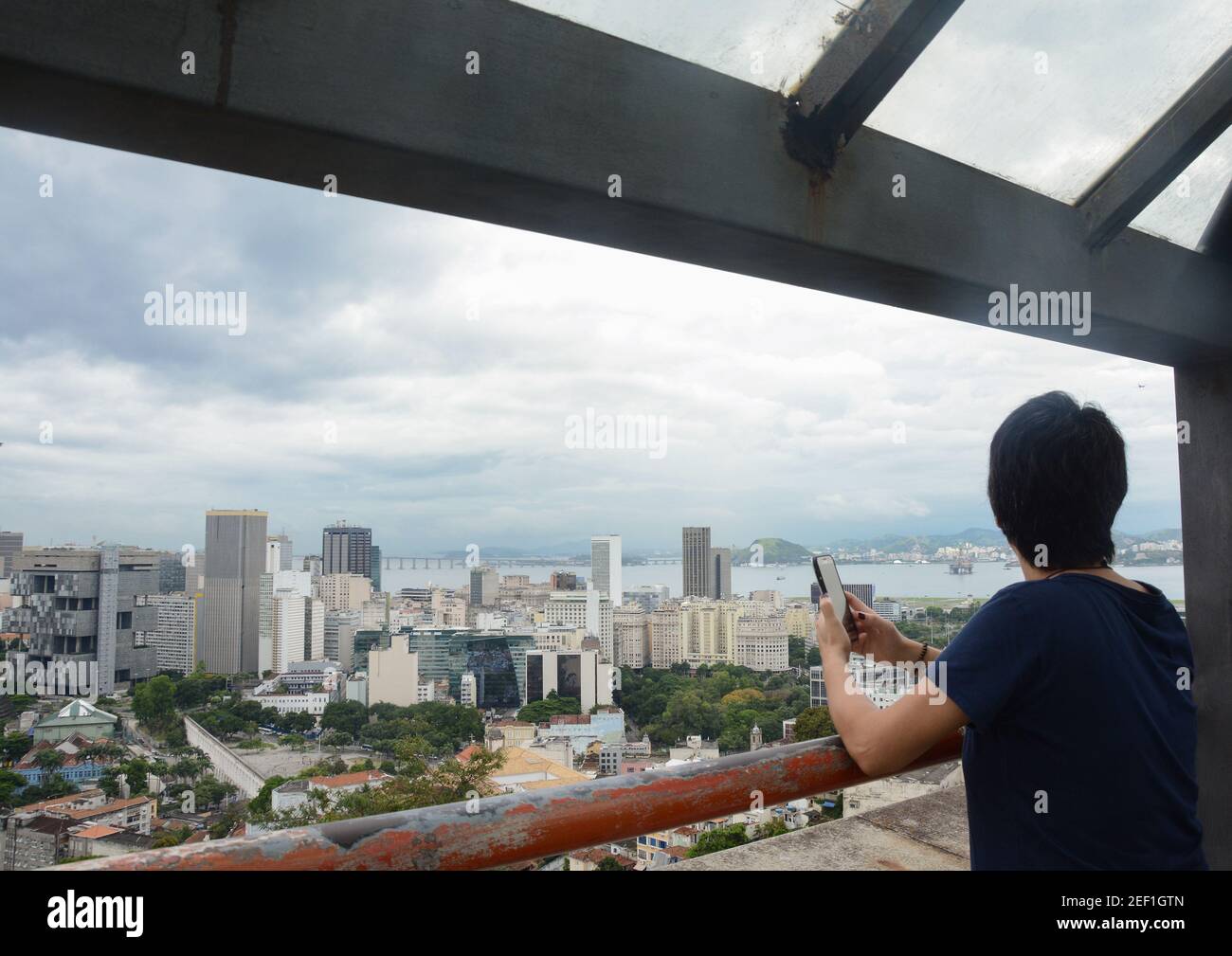 RIO DE JANEIRO, BRASILE - 3 GENNAIO 2020: Donna non identificata con un telefono cellulare guarda la vista panoramica del centro di Rio con importanti edifici, Foto Stock