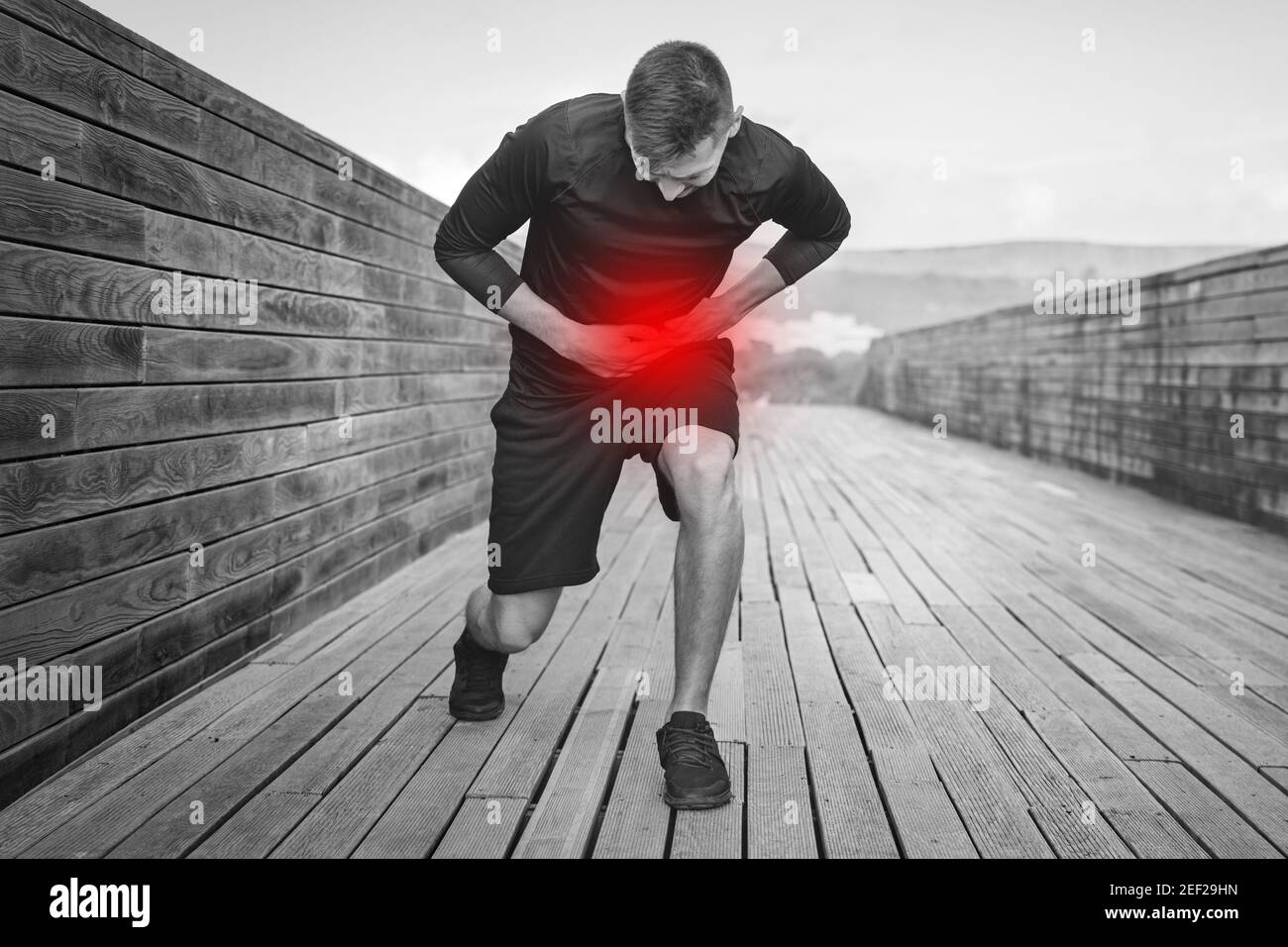Man Runner con cuciture laterali o crampi durante l'allenamento. Atleta che soffre di dolore laterale dopo jogging o corsa. Foto Stock