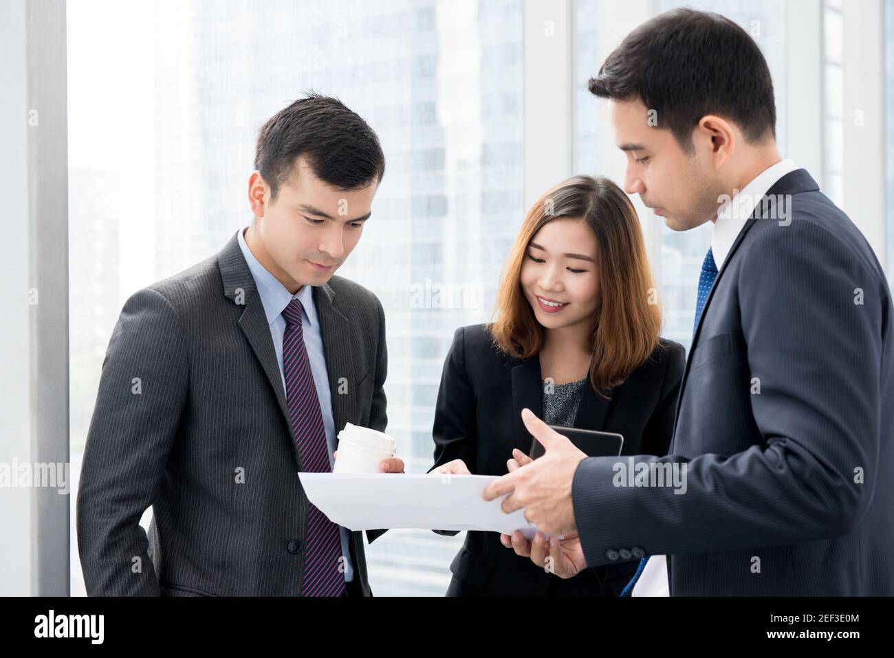 Uomini d'affari multietnici che discutono di lavoro nel corridoio degli uffici Foto Stock