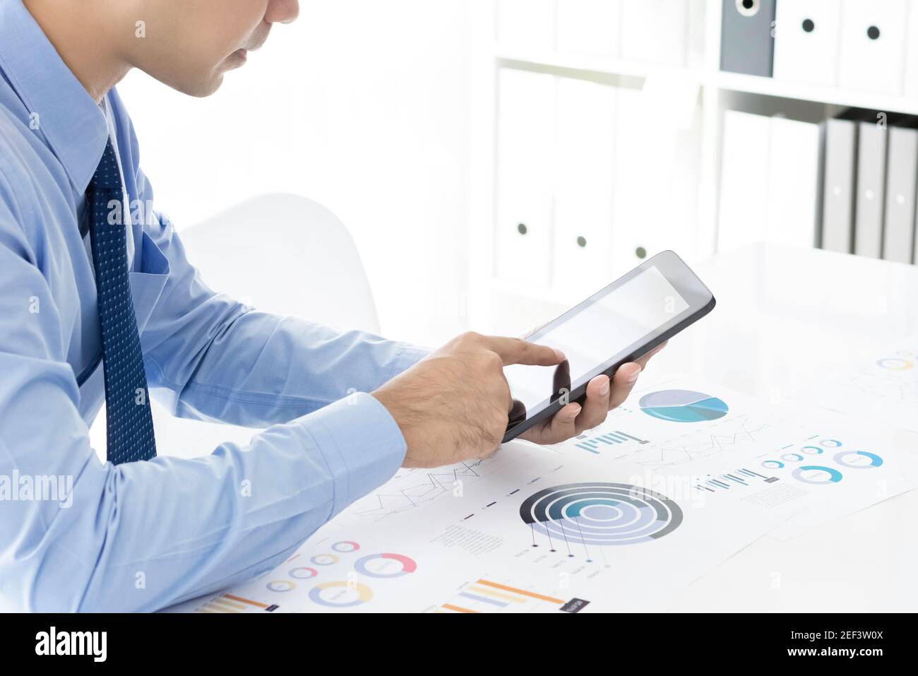 Uomo d'affari che utilizza un computer tablet che analizza i dati del grafico finanziario sul ufficio Foto Stock