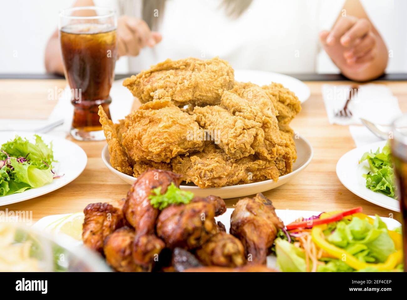 Pollo, insalata e bevanda sul tavolo da pranzo, pronto a mangiare Foto Stock