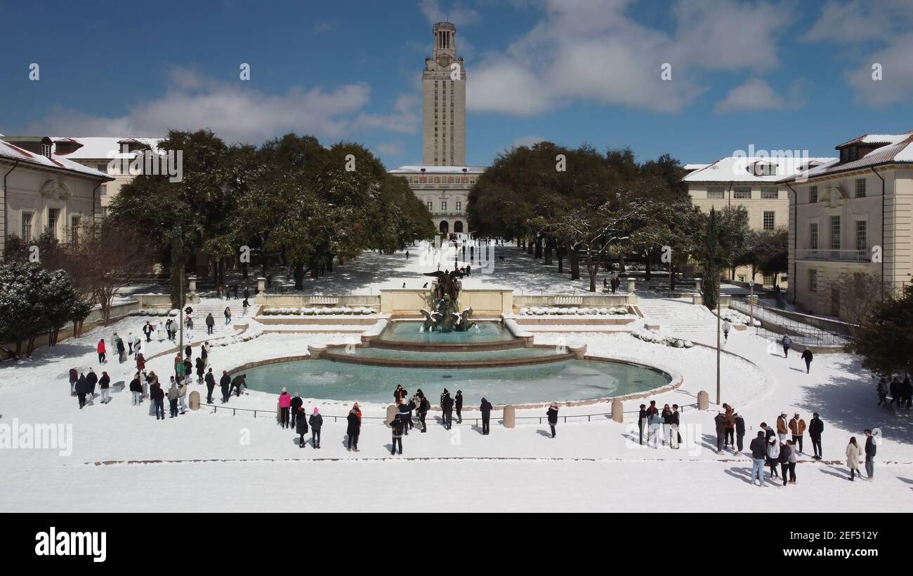 Austin, Texas - 15 febbraio 2021: Gli studenti del college giocano nella neve vicino alla fontana e alla torre dell'Università del Texas dopo una tempesta di neve Foto Stock