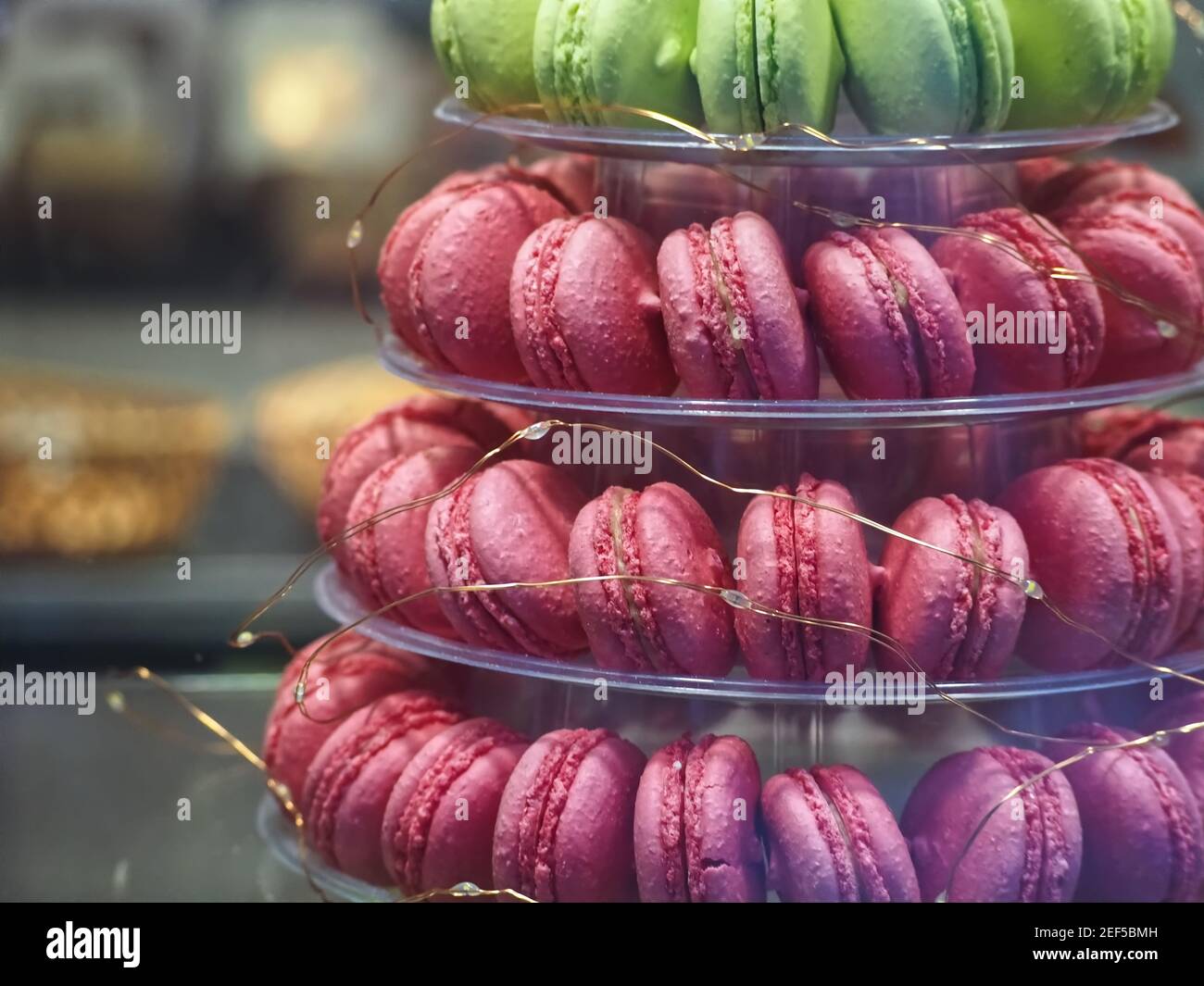 Macaroni verdi e rosa su un supporto per torte Foto Stock