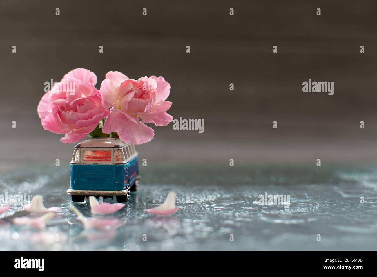 Vecchia macchina giocattolo decorata con fiori di garofano rosa Foto Stock