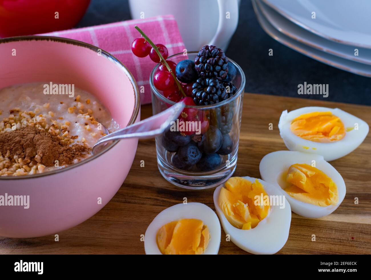 colazione vegetariana con ciotola di porridge, frutti di bosco freschi e uova sode Foto Stock