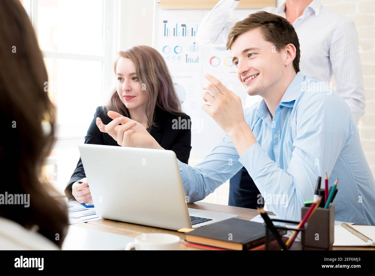 Felice uomo d'affari che discute di lavoro con i suoi colleghi durante la riunione Foto Stock