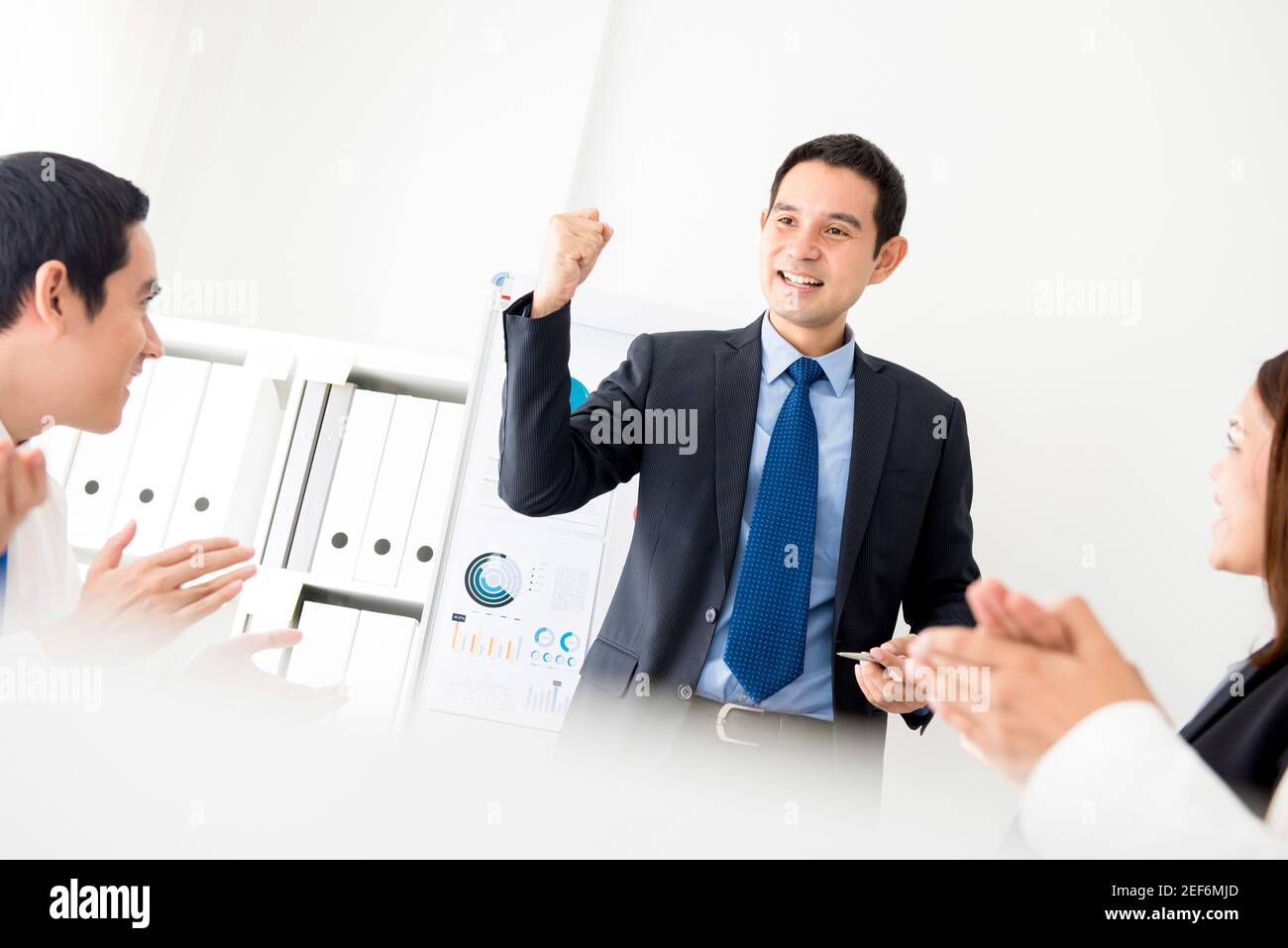 Un uomo d'affari potente come un leader di riunione che aggrava la sua forza i suoi colleghi di fronte alla camera Foto Stock
