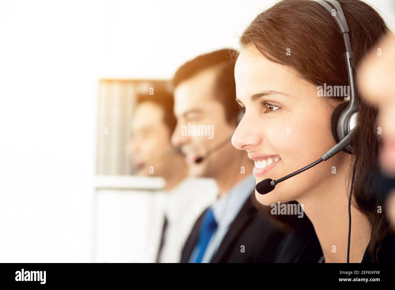 Team sorridente del call center (o telemarketer) che lavora in ufficio Foto Stock