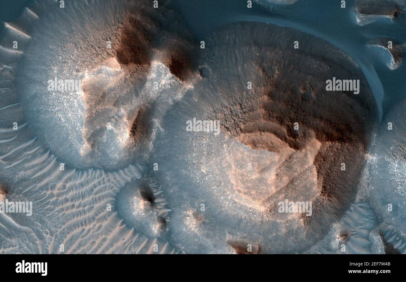 Handout foto di diversi crateri in Arabia Terra sono riempiti di roccia stratificata, spesso esposti in tumuli arrotondati. Gli strati luminosi hanno approssimativamente lo stesso spessore, dando un aspetto a scala. Il processo che ha formato queste rocce sedimentarie non è ancora ben compreso. Avrebbero potuto formarsi da sabbia o cenere vulcanica che è stata soffiata nel cratere, o in acqua se il cratere ospitava un lago. Una cosa è certa, però: Non sarebbe difficile ottenere i vostri 10,000 passi giornalieri quando si fa un'escursione nella bellissima Arabia Terra! L'agenzia spaziale americana afferma che la sua perseveranza rover è perfettamente allineata Foto Stock