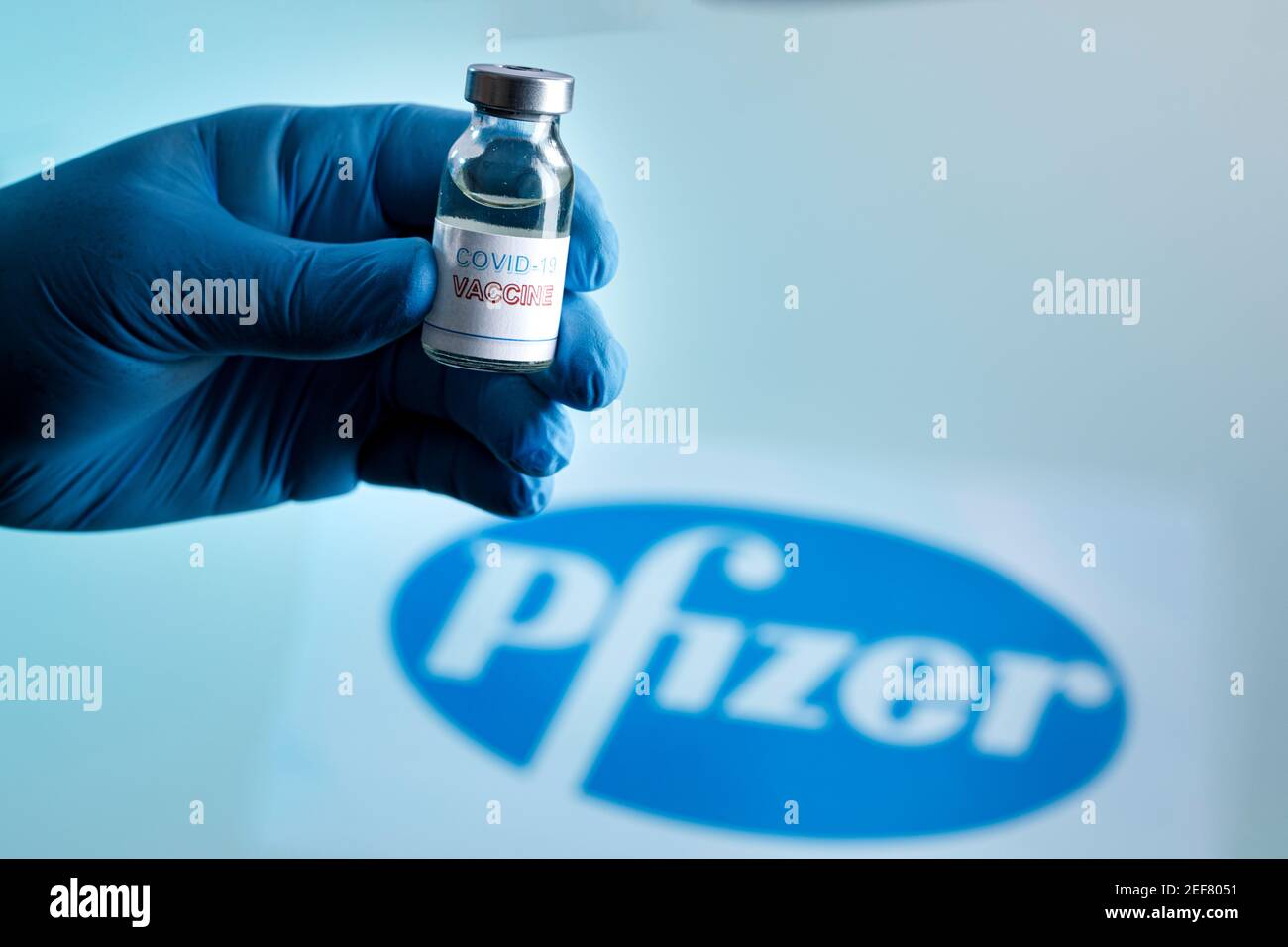 Flacone di vaccino del coronavirus e sullo sfondo la marca di l'azienda farmaceutica pfizer Foto Stock