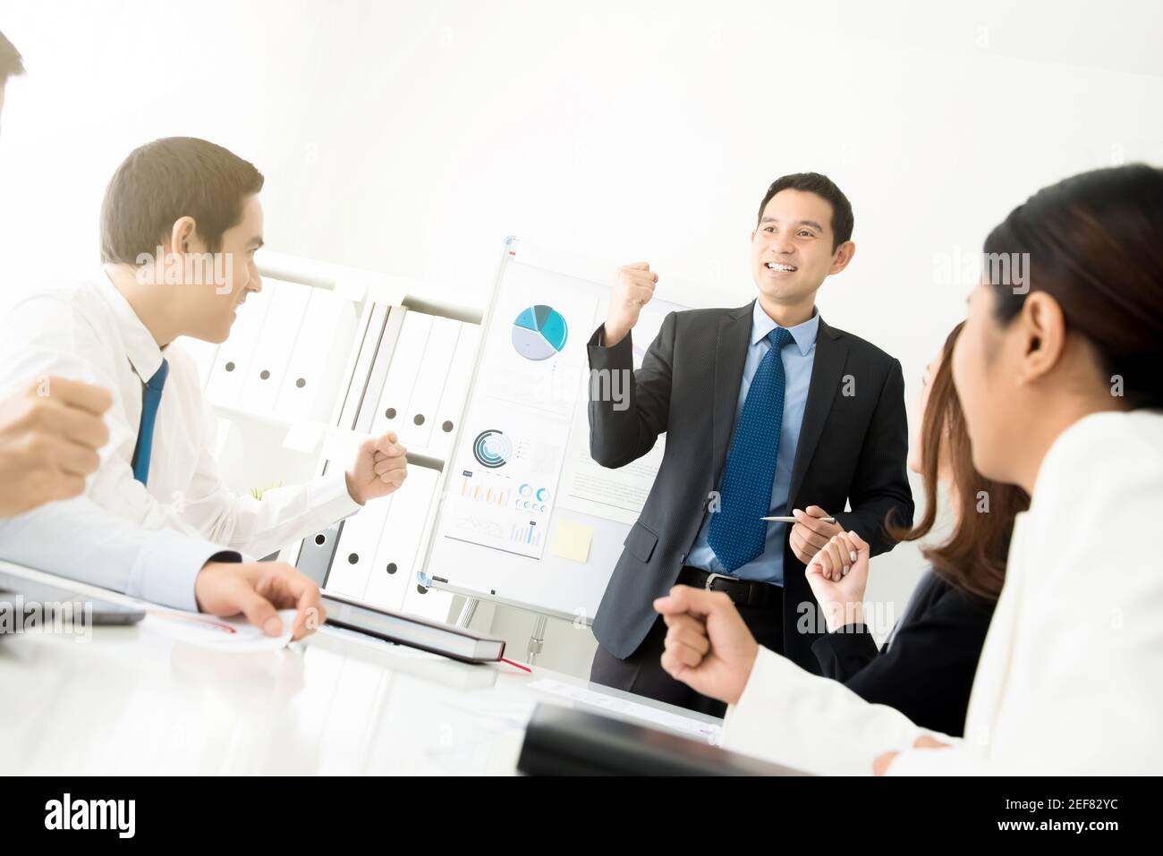 Un uomo d'affari potente come un leader di riunione che aggrava la sua forza i suoi colleghi di fronte alla camera Foto Stock