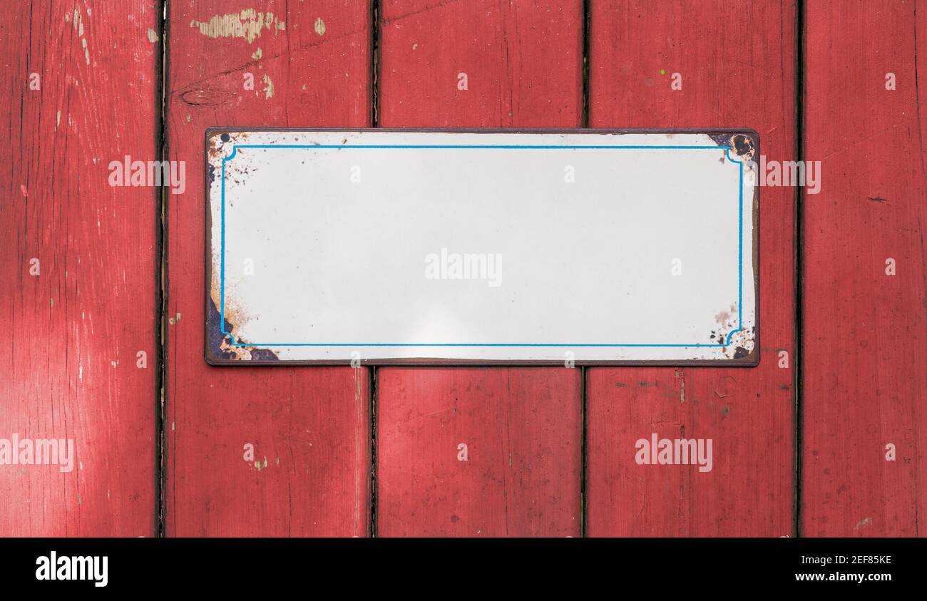 Cartello di stagno vuoto di fronte a un muro di legno Foto Stock