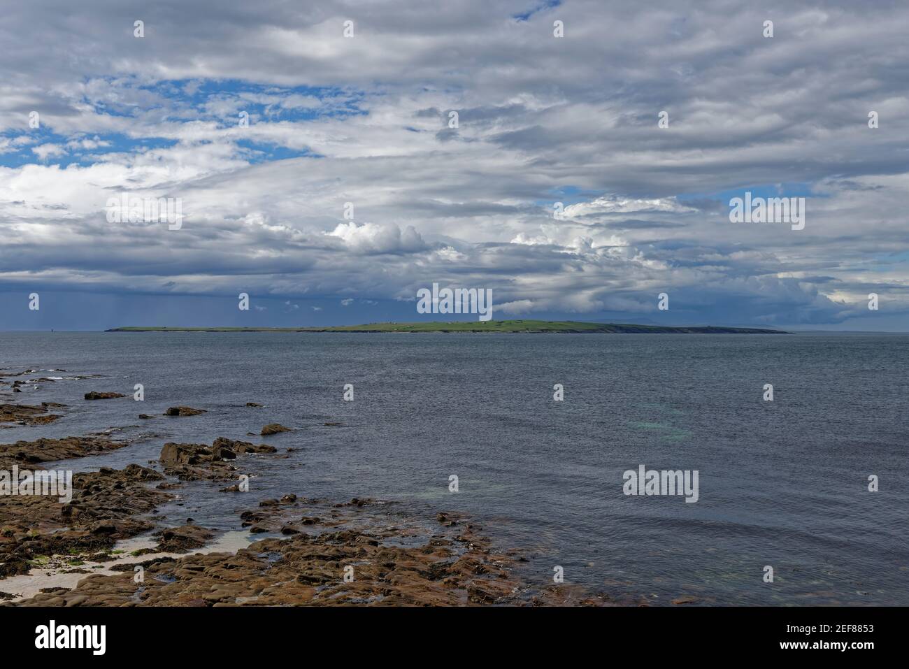 Guardando dall'altra parte dell'isola di stroma, parte delle Orkneys dalla spiaggia rocciosa di John OÕGroats in un bel tardo pomeriggio di maggio. Foto Stock