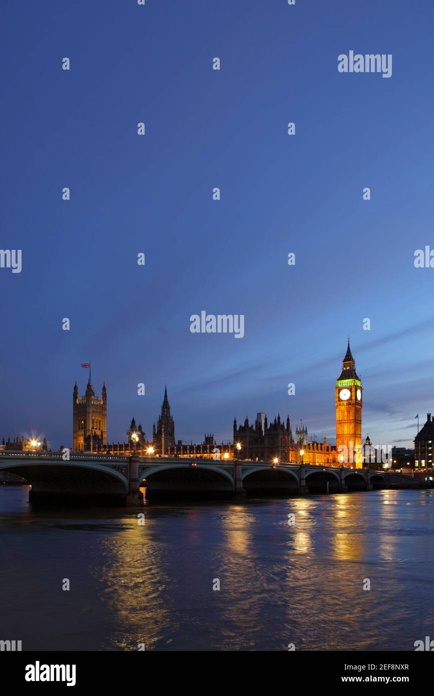 Palazzo di Westminster al tramonto, visto attraverso il fiume Thames, London, Regno Unito Foto Stock