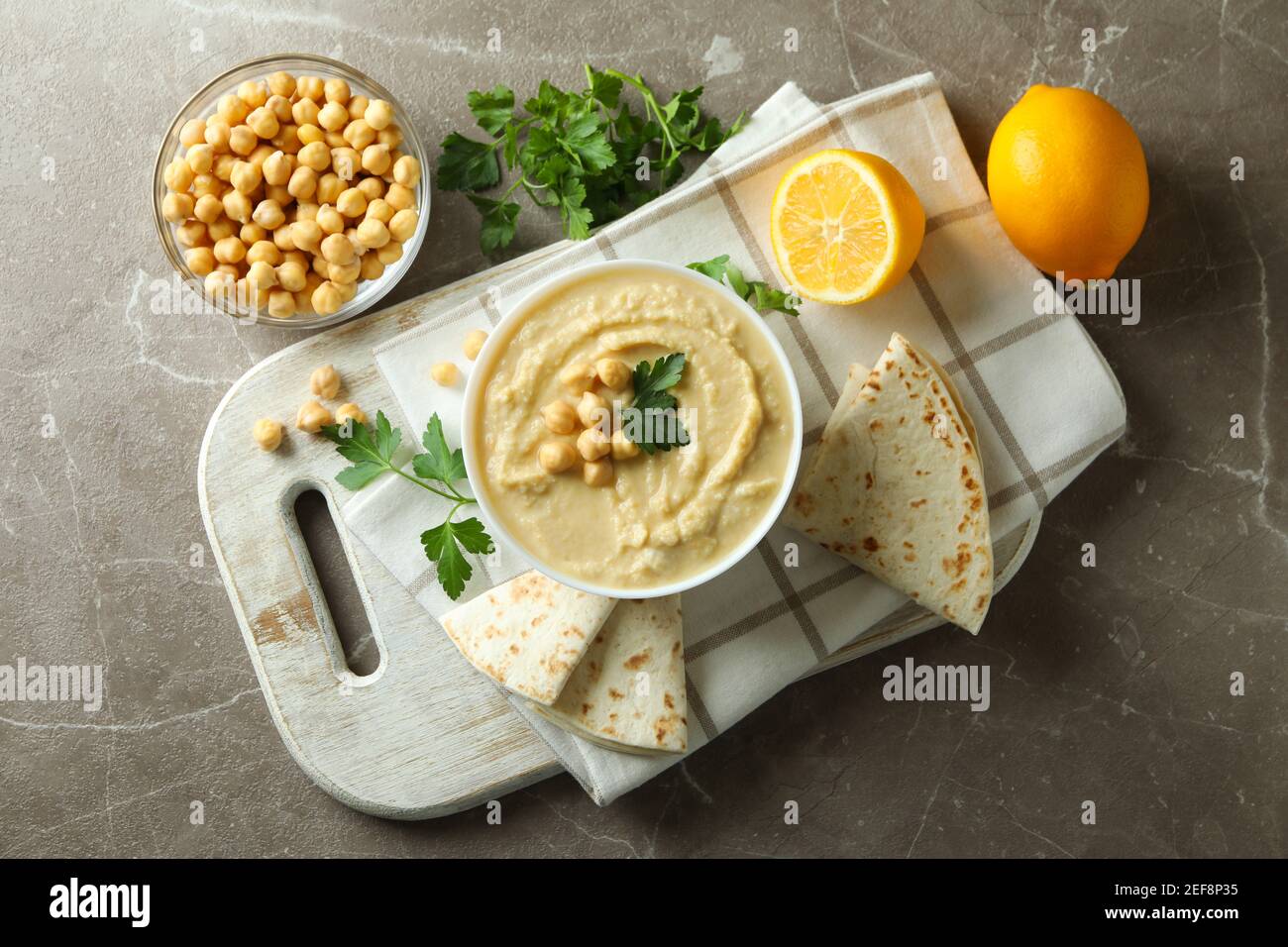 Concetto di mangiare gustoso con ciotola di hummus su grigio sfondo Foto Stock