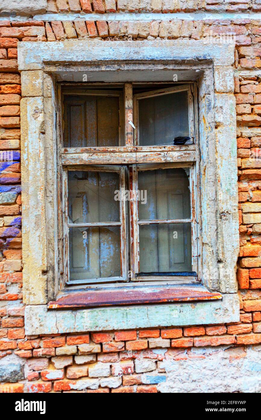 Finestra in legno invecchiata e muro in mattoni rovinati Foto Stock