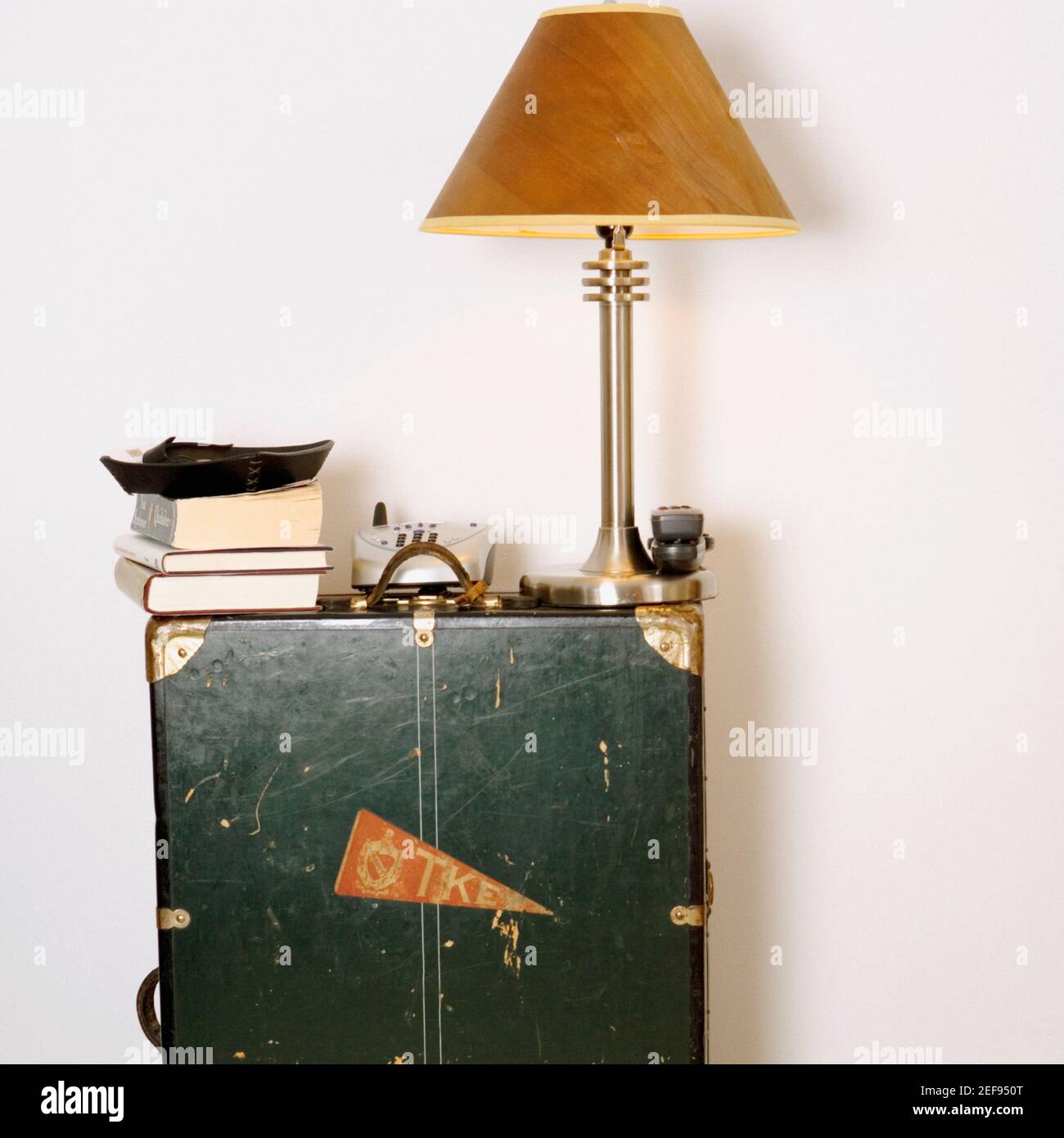 Paralume lampada con telefono cordless e libri su a. armadio Foto Stock