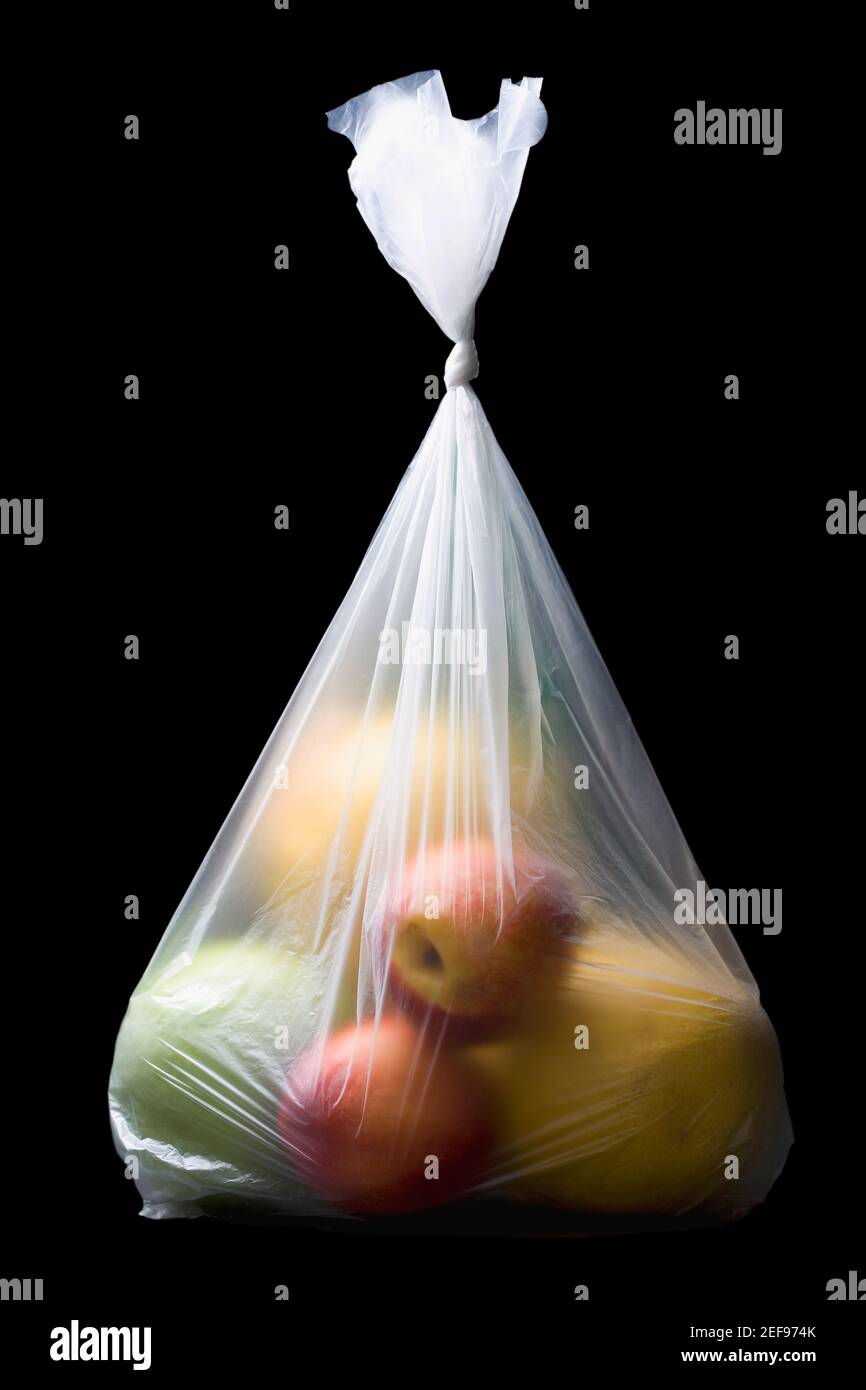 Primo piano di due mele e tre arance in plastica borsa Foto Stock