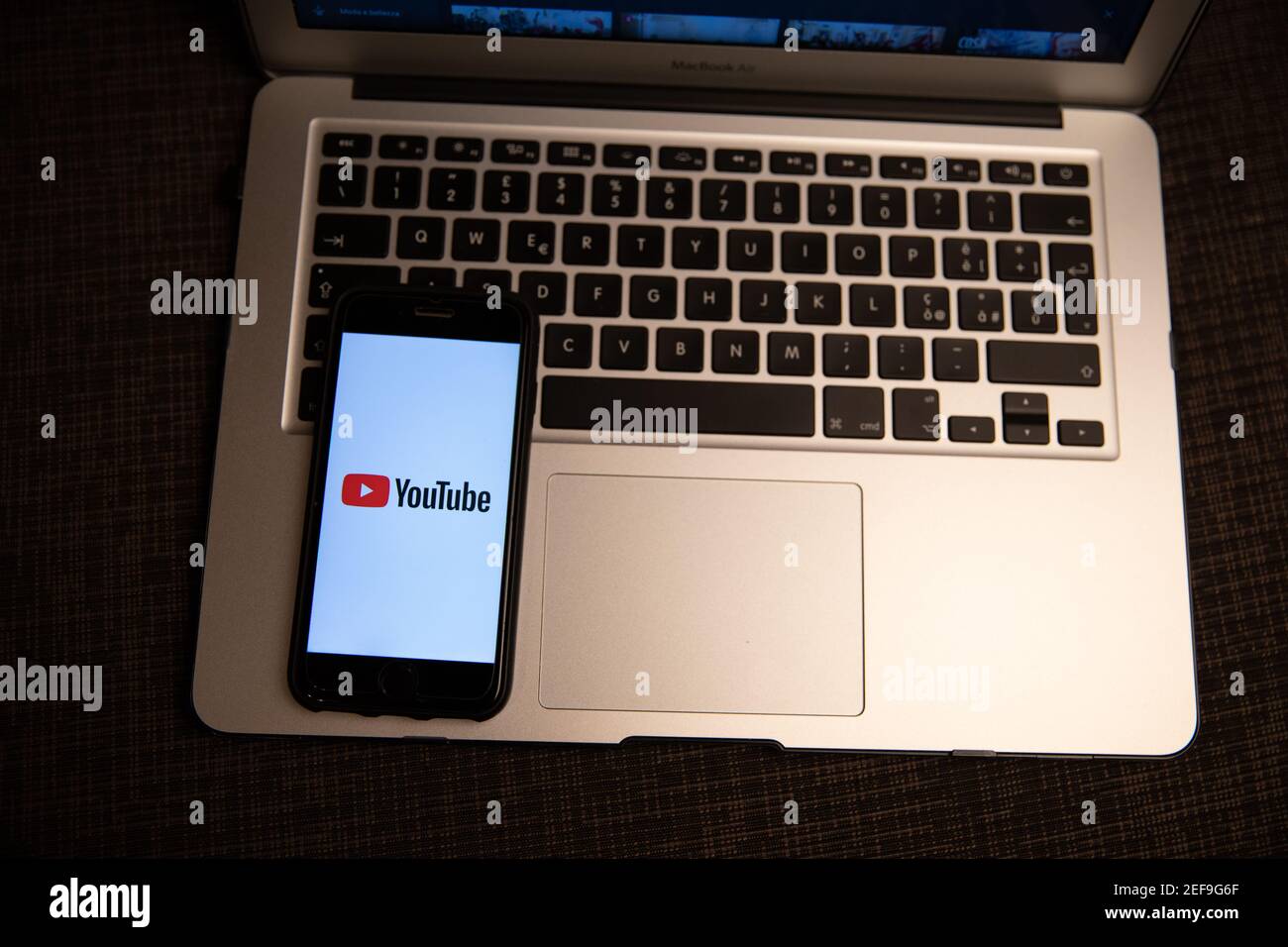 Smartphone con il logo YouTube poggiato sulla tastiera di un computer portatile. YouTube è una piattaforma di condivisione video online americana, uno dei siti Web più visitati. Foto Stock