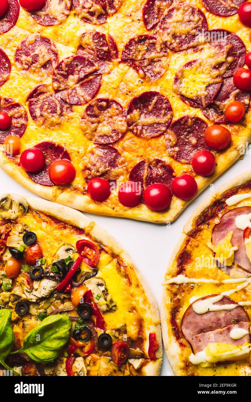 diverse pizze di vario genere in assortimento con basilico verde, primo piano Foto Stock