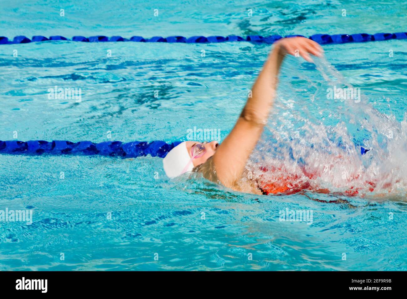 Profilo laterale di una giovane donna di nuoto in piscina Foto Stock