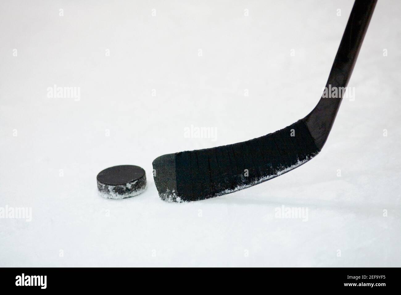 Primo piano di un bastone da hockey su ghiaccio con un disco da hockey Foto Stock