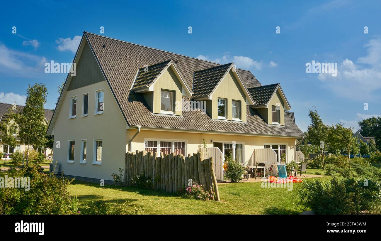 Idilliaca grande casa con un giardino verde nel villaggio in estate Foto Stock