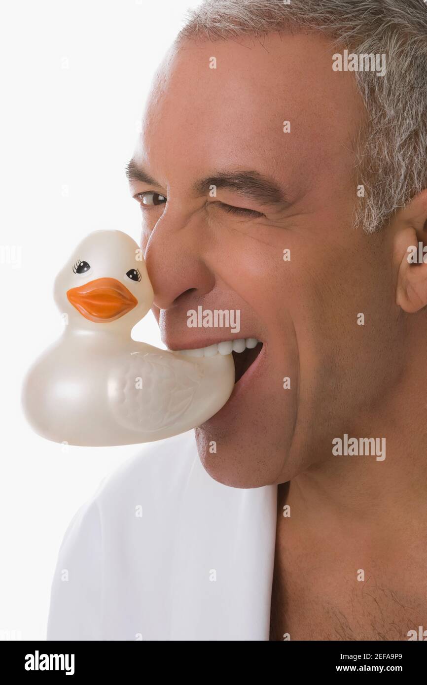 Ritratto di un uomo anziano che tiene un'anatra giocattolo dentro la sua bocca Foto Stock