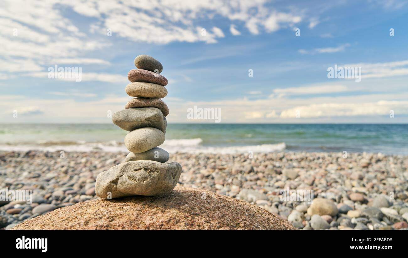 Concetto di meditazione buddismo e zen con una pila di pietre la spiaggia sul mare Foto Stock