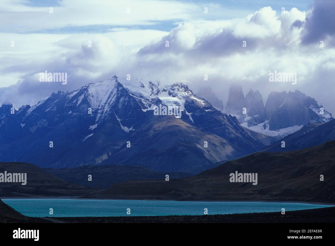 Nubi su montagne coperte di neve Foto Stock