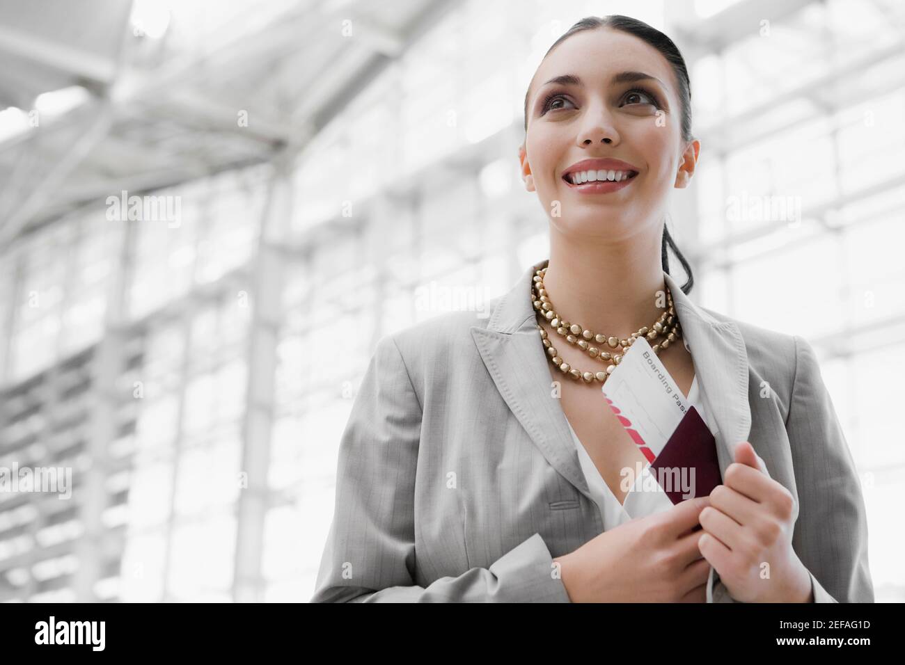 Primo piano di una donna d'affari che mette un passaporto con un aereo Biglietto in tasca coatÅ½s Foto Stock