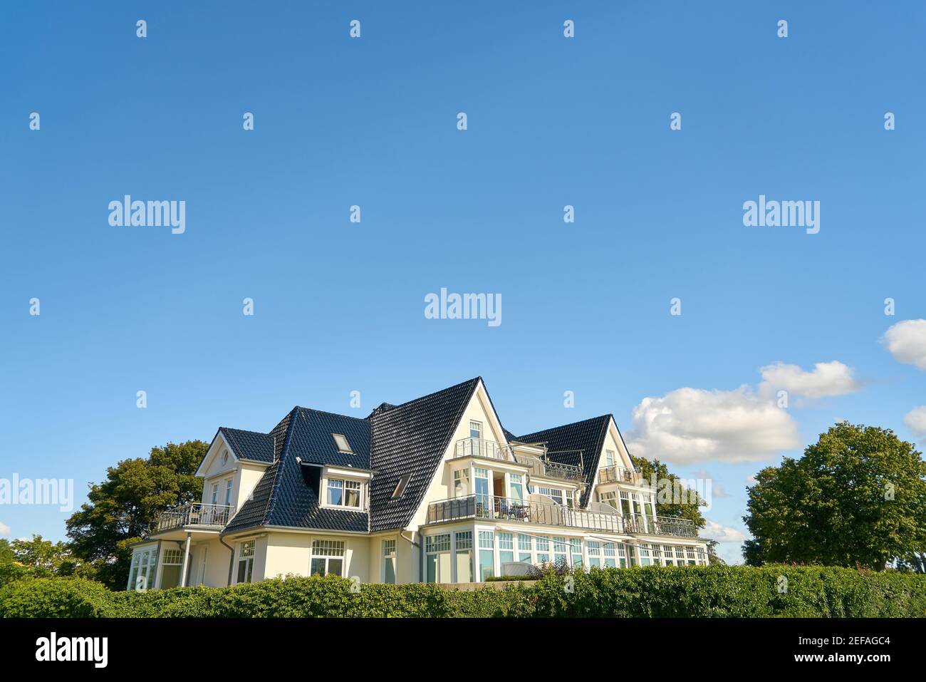 Bella villa grande con terrazza e giardino contro un blu cielo Foto Stock