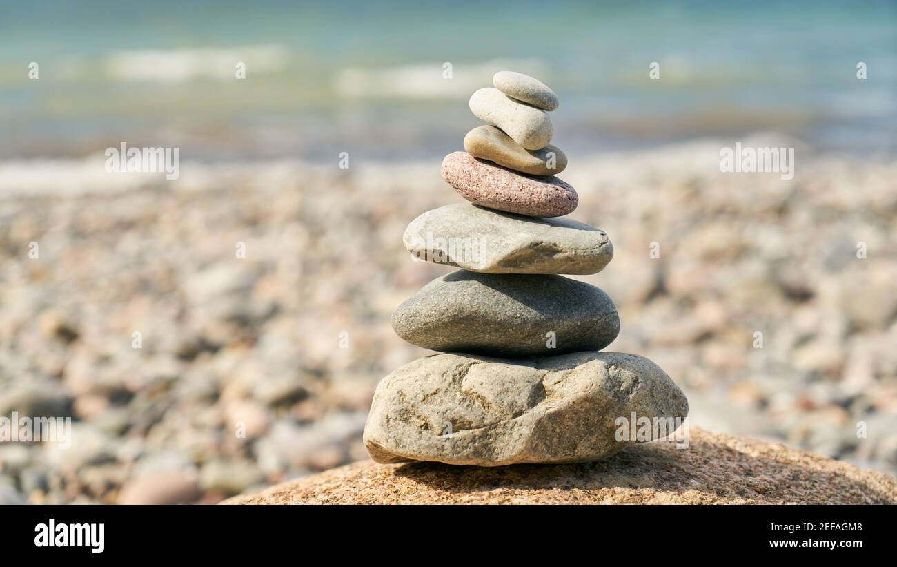 Alto mucchio di pietre come il concetto di meditazione del Buddismo di Zen sopra la spiaggia sul mare Foto Stock