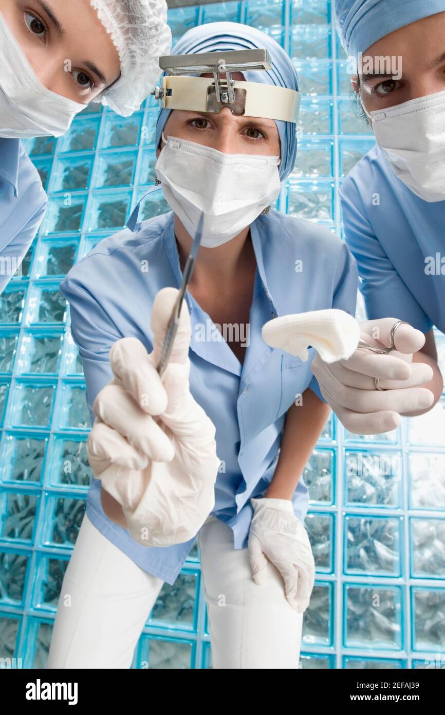 Due chirurghi femminili e un chirurgo maschile in un operatorio camera Foto Stock
