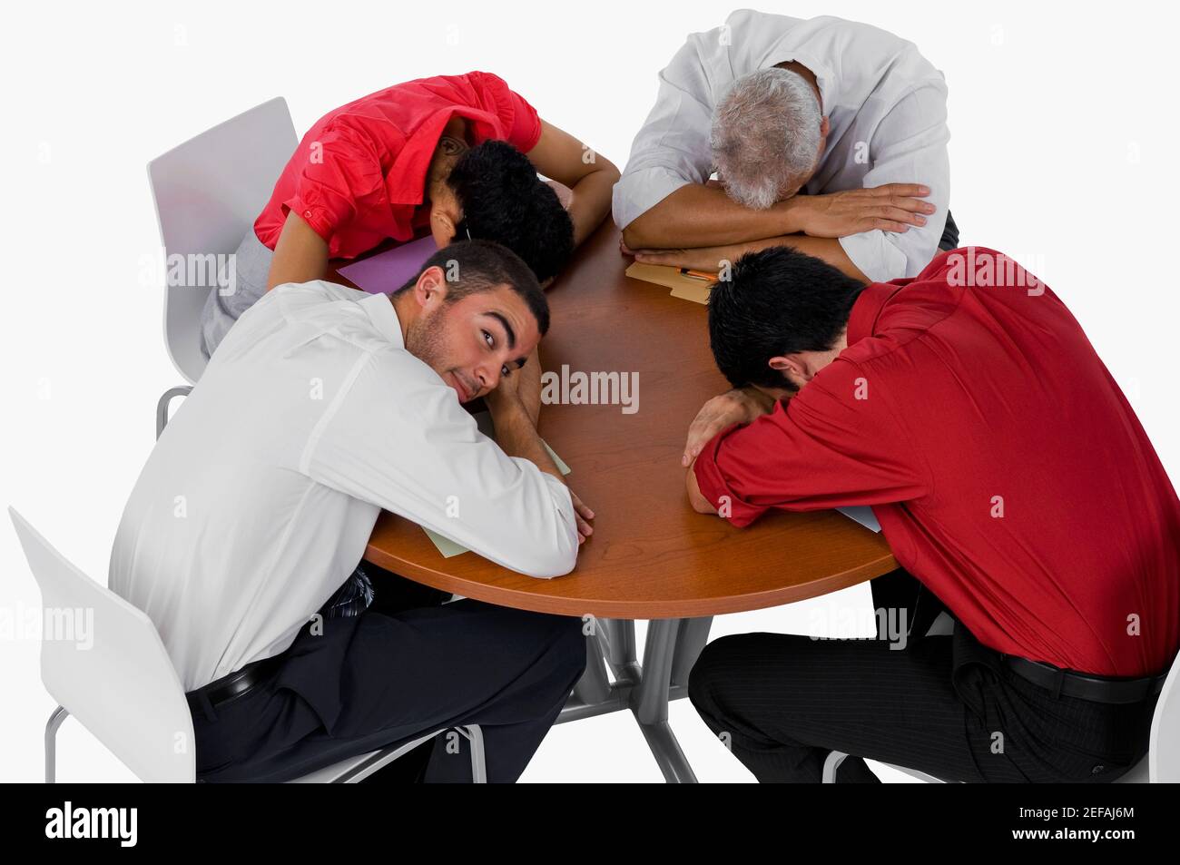 Vista ad alto angolo di tre uomini d'affari e di una donna d'affari che riposa le loro teste su un tavolo Foto Stock
