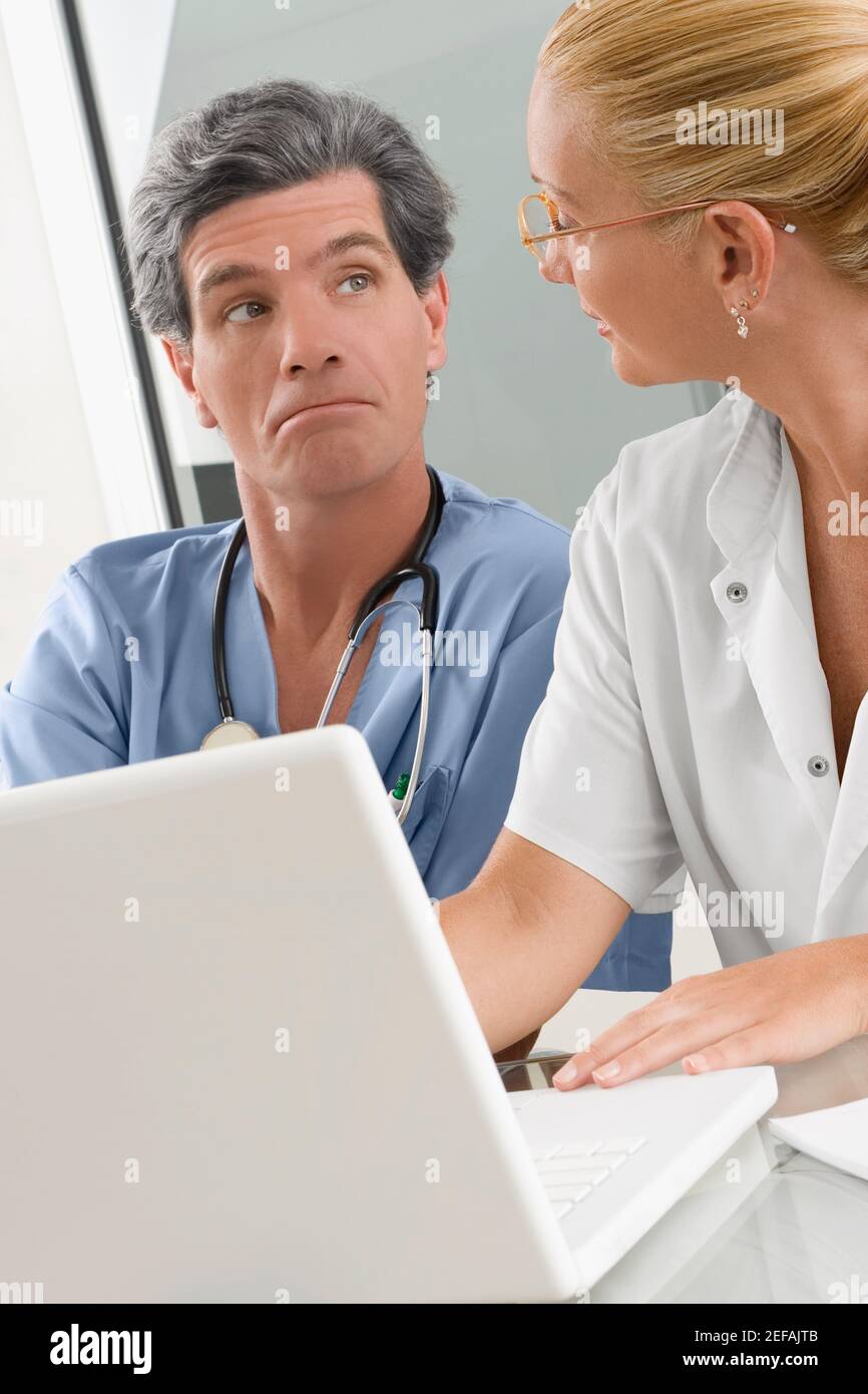 Medico femminile che discute con un chirurgo maschile Foto Stock