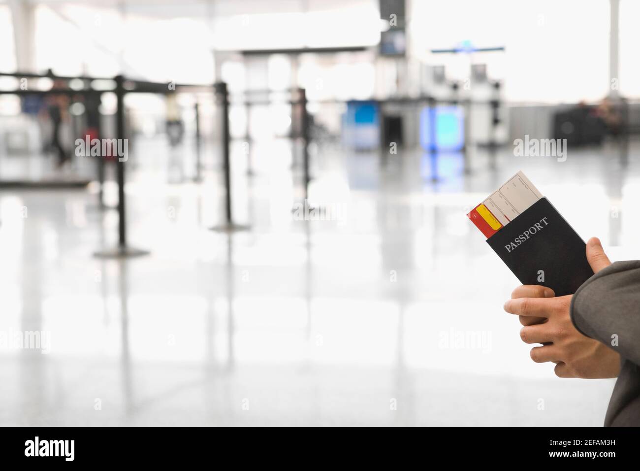 Close up di una mano di personÅ½s che tiene un passaporto con un biglietto aereo Foto Stock