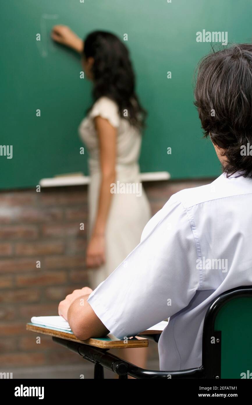 Insegnante femminile che insegna il suo studente in una classe Foto Stock