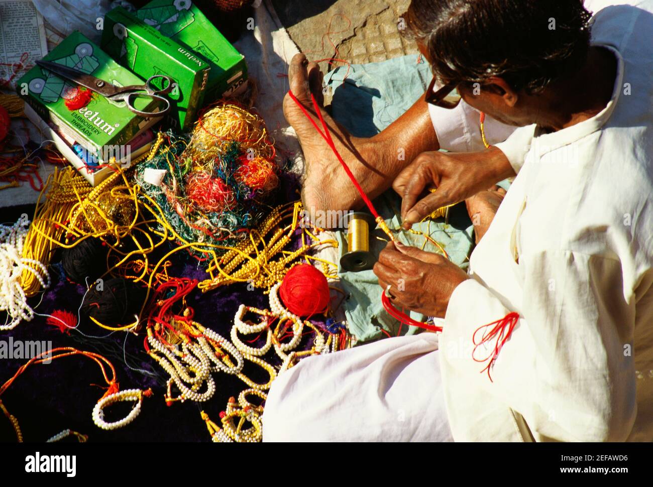 Vista ad alto angolo di un uomo maturo che fa i braccialetti, Jaipur, Rajasthan, India Foto Stock