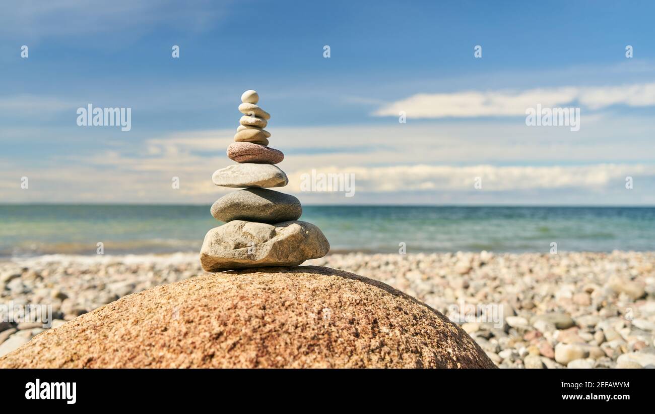 Il concetto di Buddismo Zen per la meditazione con una pila di pietre sopra La spiaggia del Mar Baltico Foto Stock