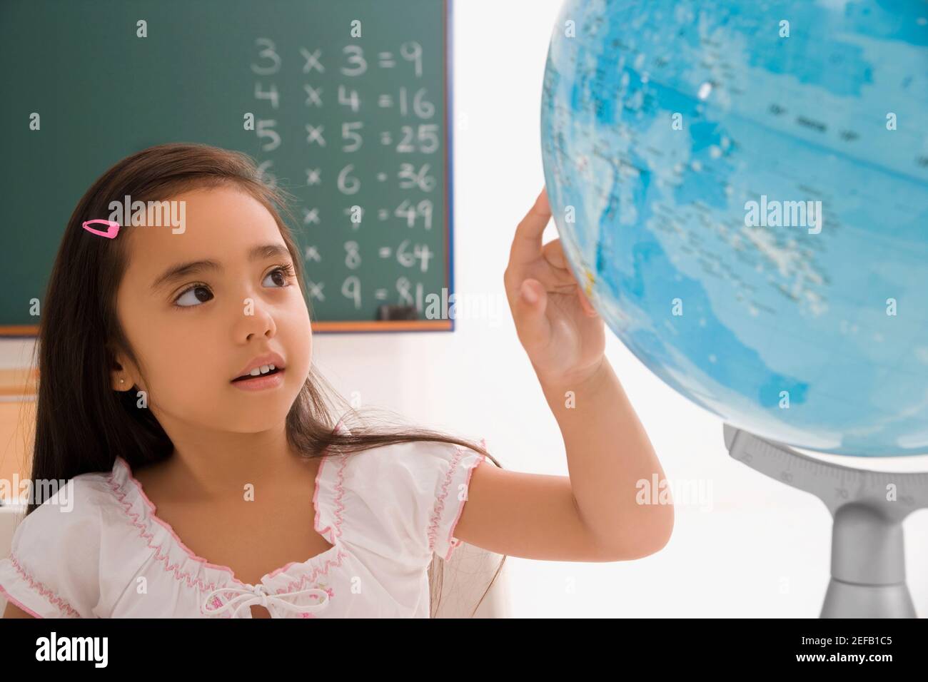 Close up di una studentessa che guarda un globo in un in aula Foto Stock