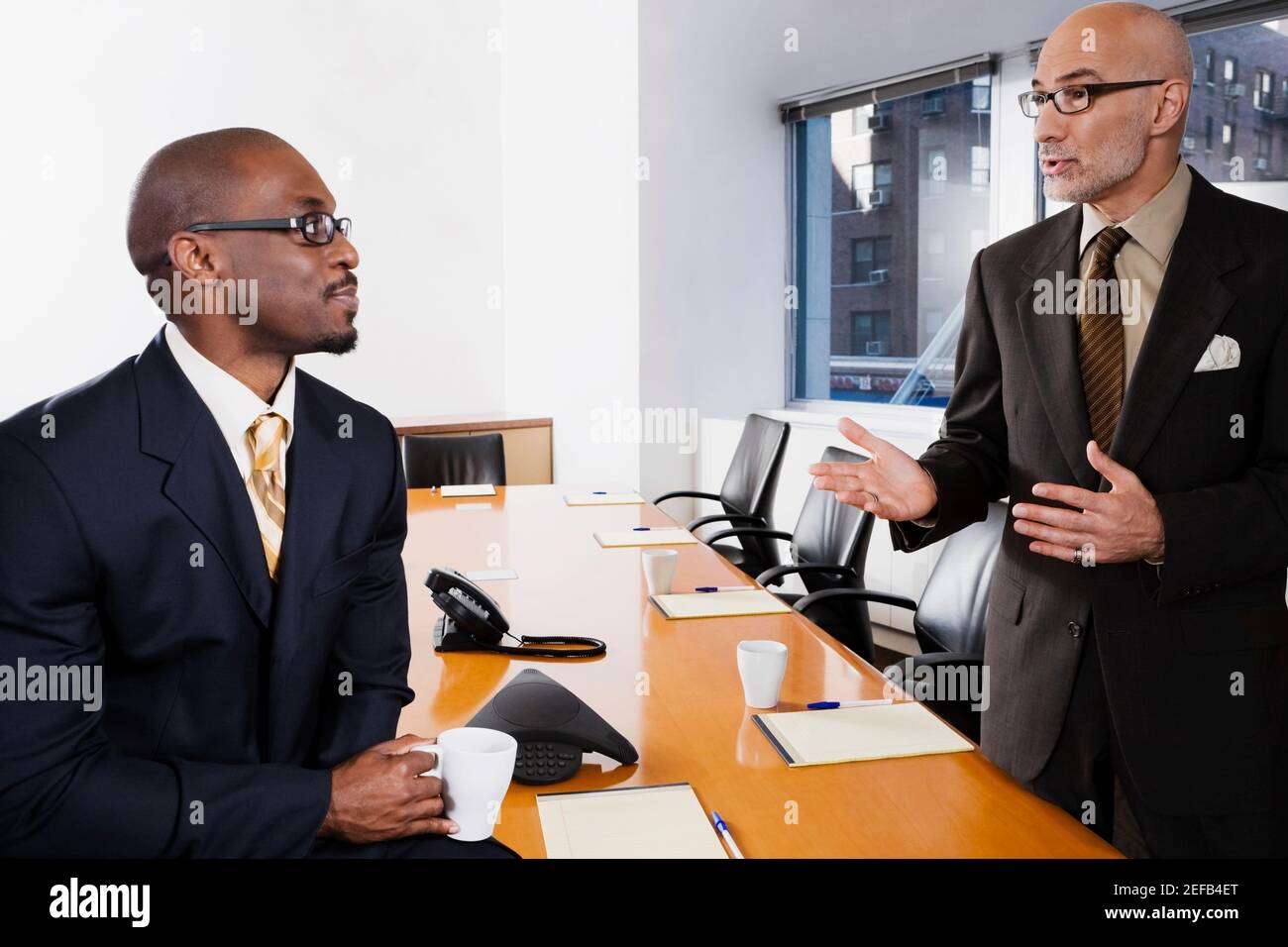 Due imprenditori di discutere in una sala conferenze Foto Stock