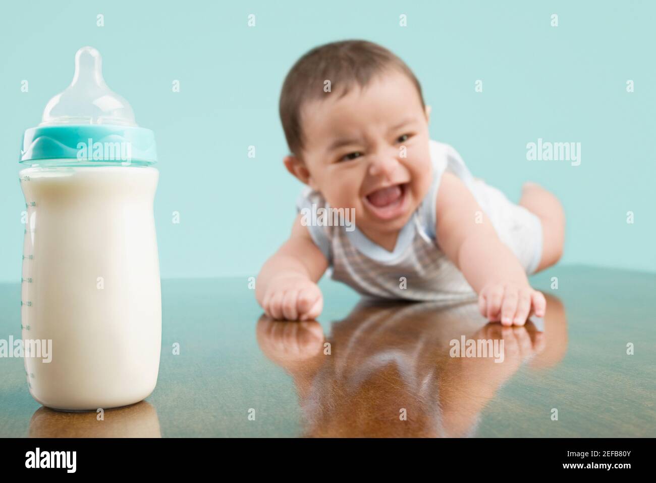 Close up di un bambino che sorride vicino a un biberon Foto Stock