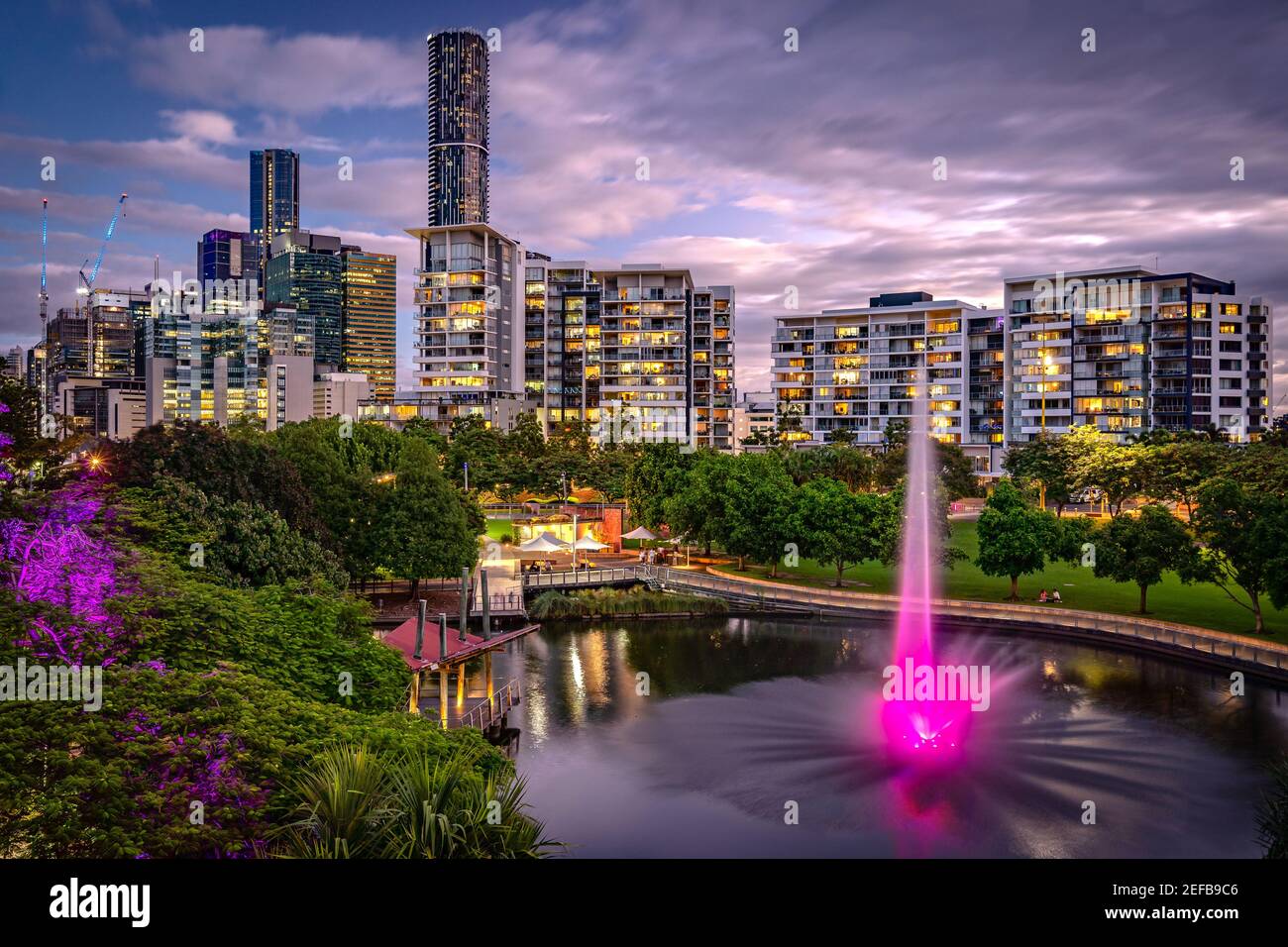 Edifici residenziali intorno al Roma Street Parkland con fontana illuminata, Brisbane, Australia Foto Stock