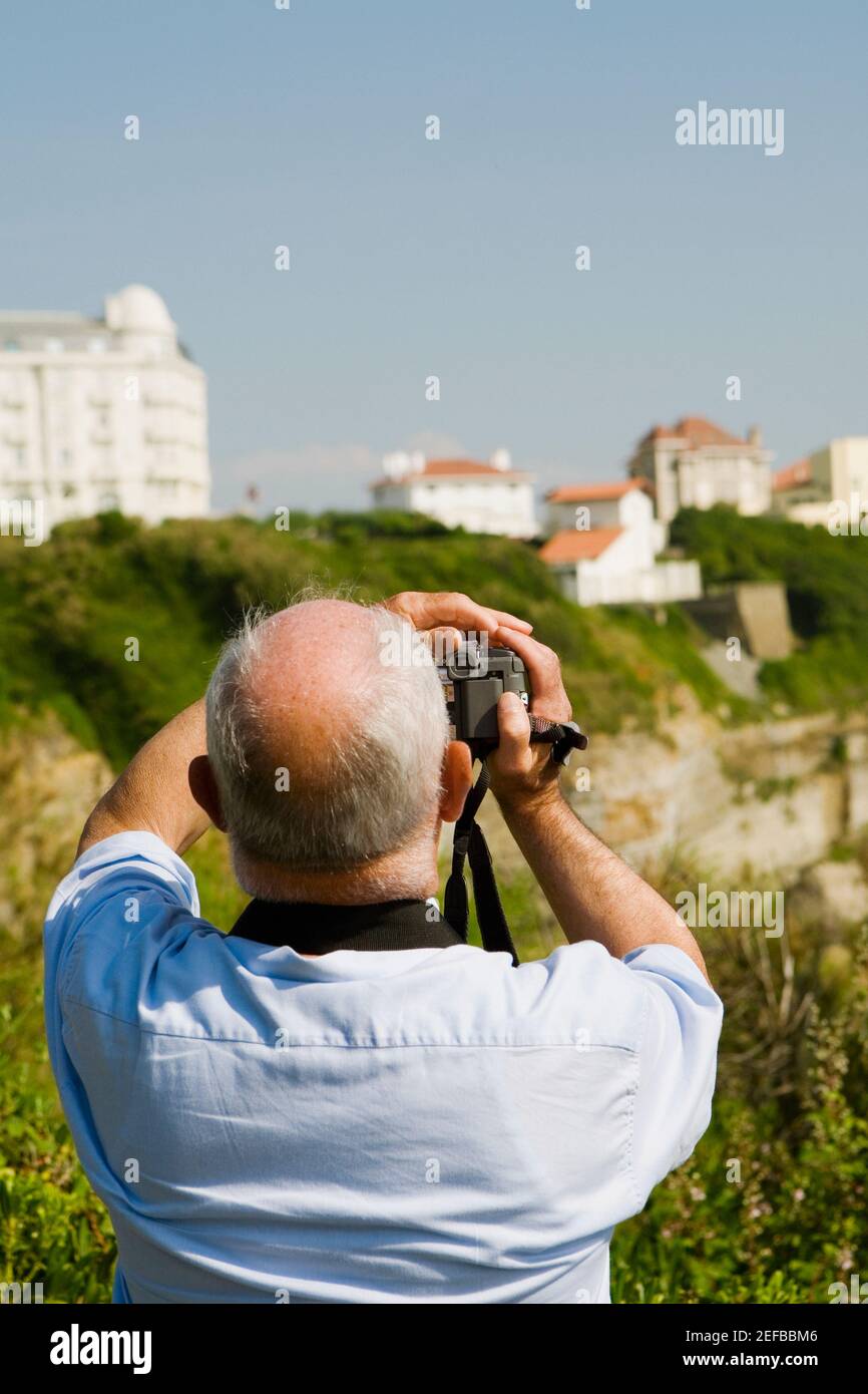 Vista posteriore di un uomo che filma con la sua videocamera domestica, Biarritz, Paesi Baschi, Pirenei Atlantici, Aquitania, Francia Foto Stock