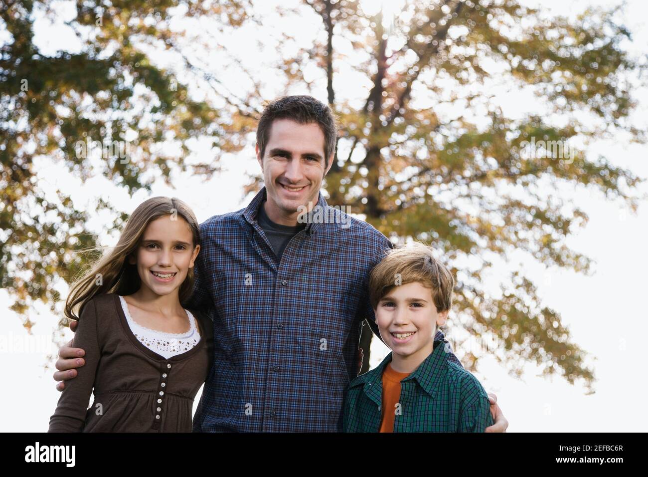 Ritratto di un giovane in piedi con i suoi due figli e sorridendo Foto Stock