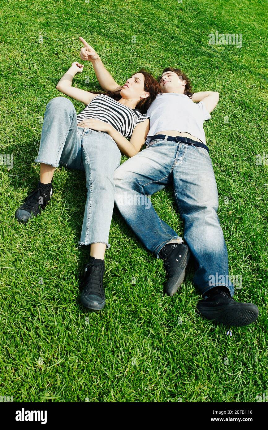 Vista ad alto angolo di una giovane coppia sdraiata sul erba in un parco Foto Stock