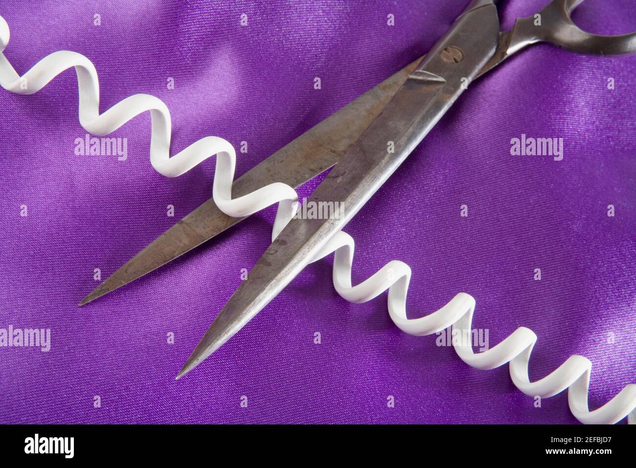 Vista ad angolo alto di un paio di forbici che tagliano a. cavo telefonico Foto Stock